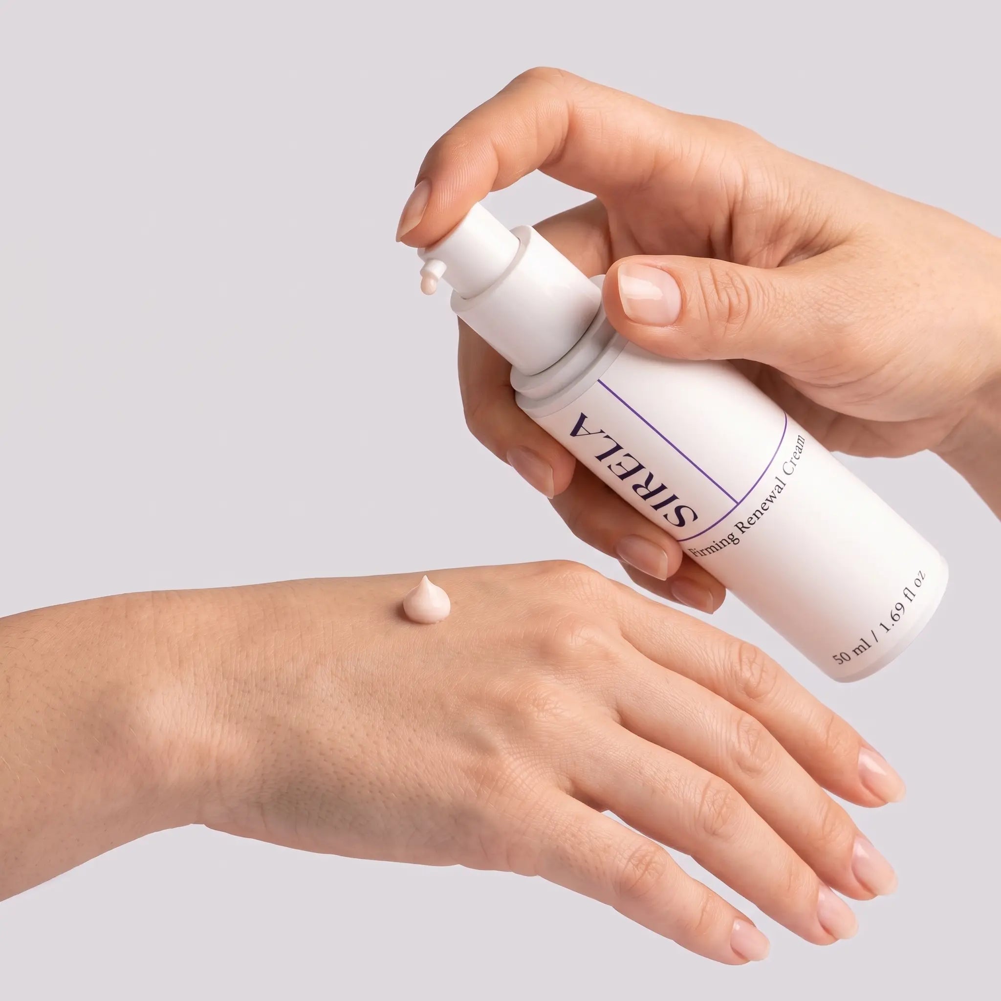 Applying Sirela Firming Renewal Cream — dispensing a pearl of pale ivory cream from the pump onto the back of the hand