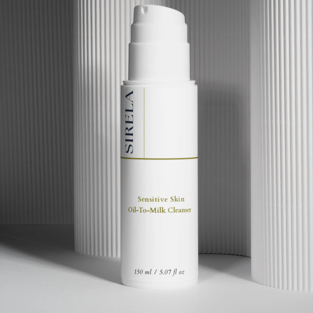Sirela Sensitive Skin Oil-To-Milk Cleanser in a clear glass bottle with a white pump on a soft neutral background