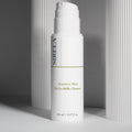 Sirela Sensitive Skin Oil-To-Milk Cleanser in a clear glass bottle with a white pump on a soft neutral background