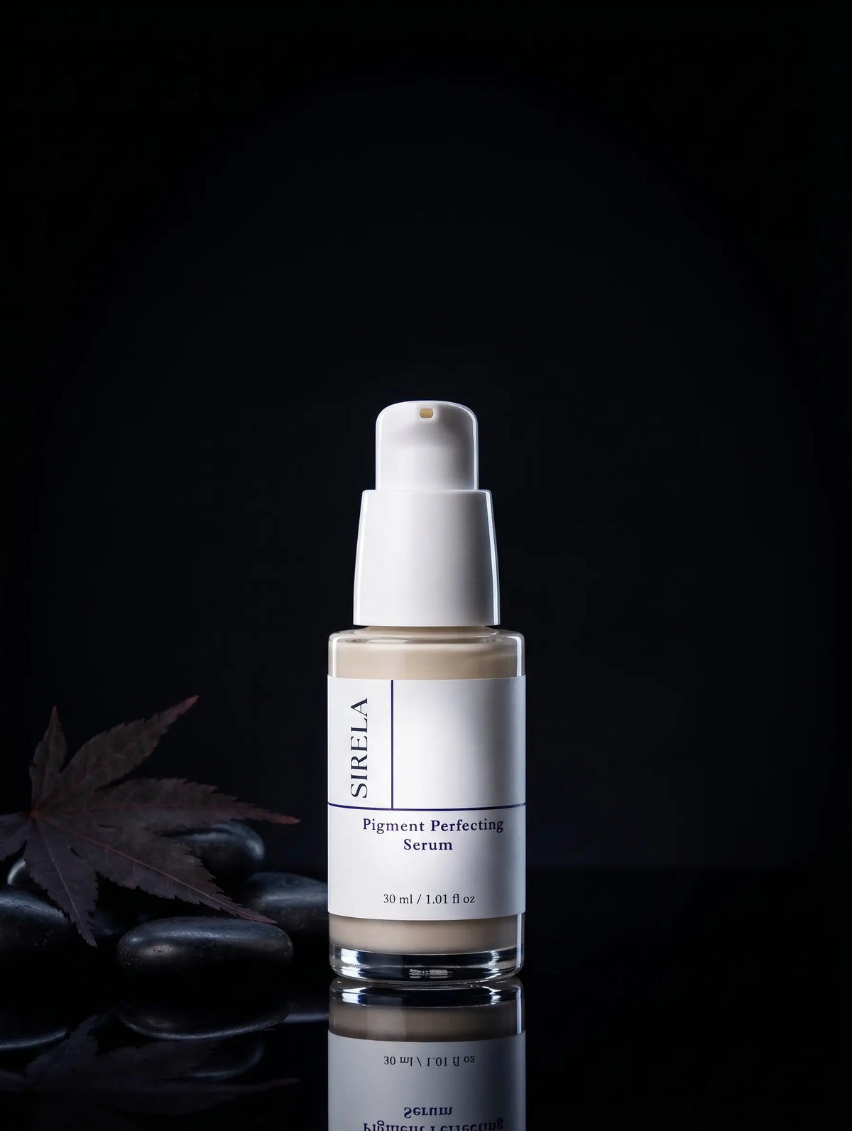 Sirela Pigment Perfecting Serum in a clear glass bottle with a white pump dispenser, set against a dark background with decorative stones and a leaf.